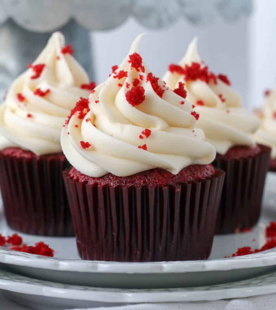 three red velvet cupcakes on a plate