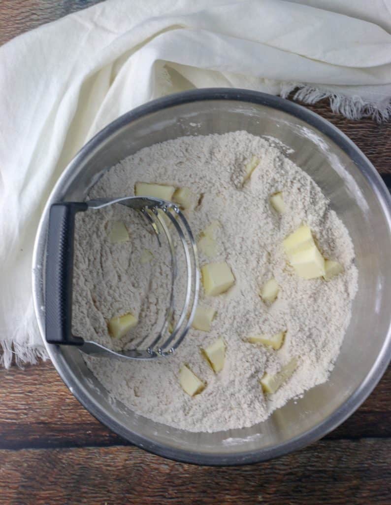 butter and flour in a bowl with a pastry cutter