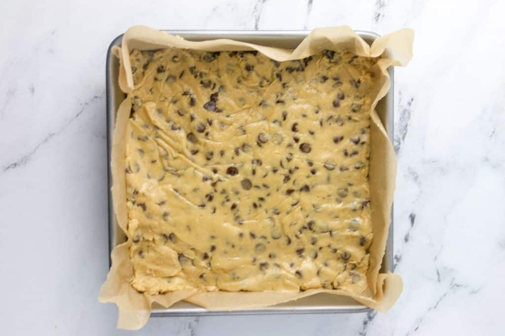 half of cookie dough pressed into bottom of pan