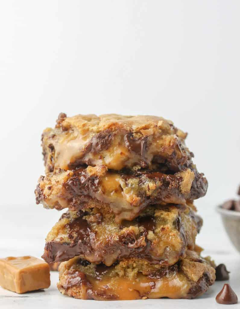 four caramel chocolate chip cookie bars stacked on top of each other