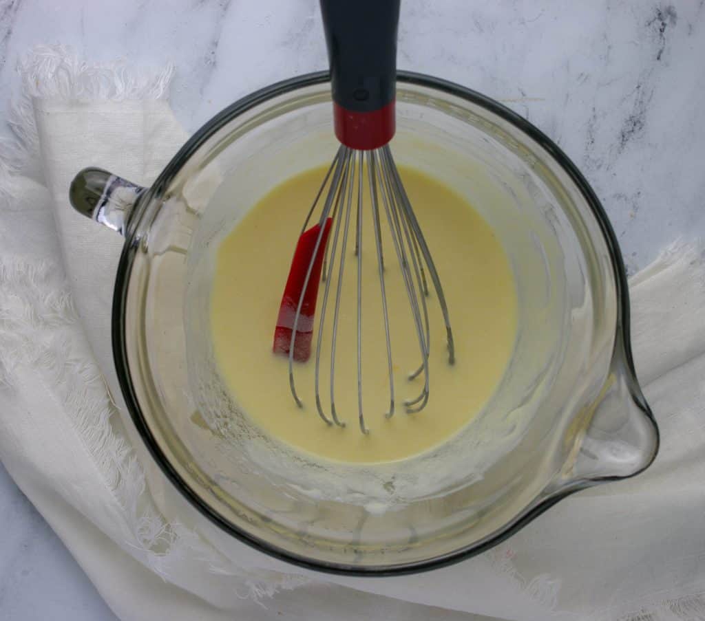 bowl of wet ingredients with whisk in it