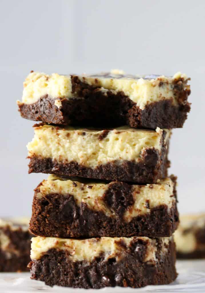 four cheesecake brownies stacked on top of each other