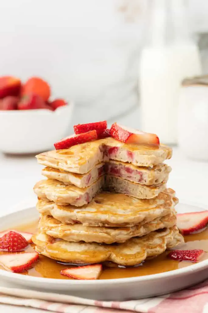 strawberry pancakes stacked with bites missing