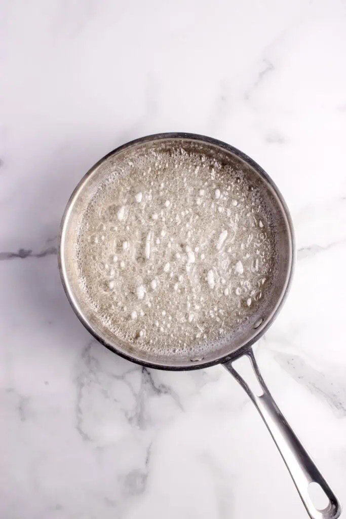sugar and water boiling in saucepan