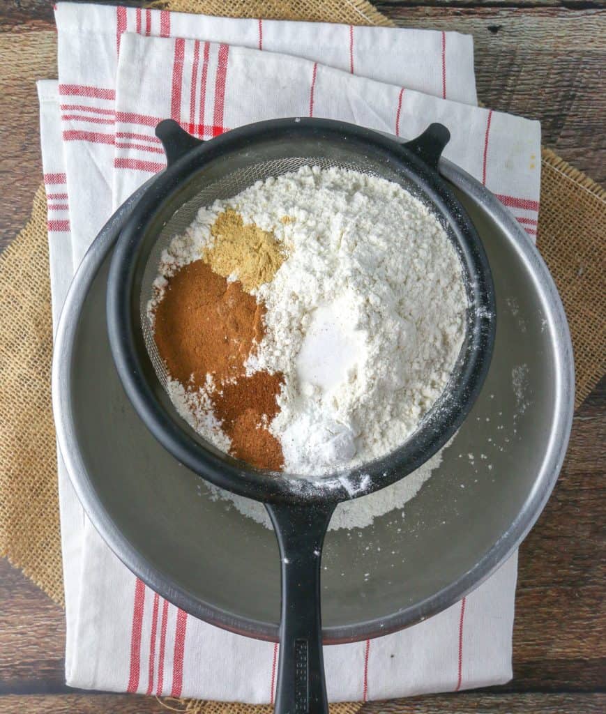 pumpkin cake dry ingredients in a sifter set over a bowl