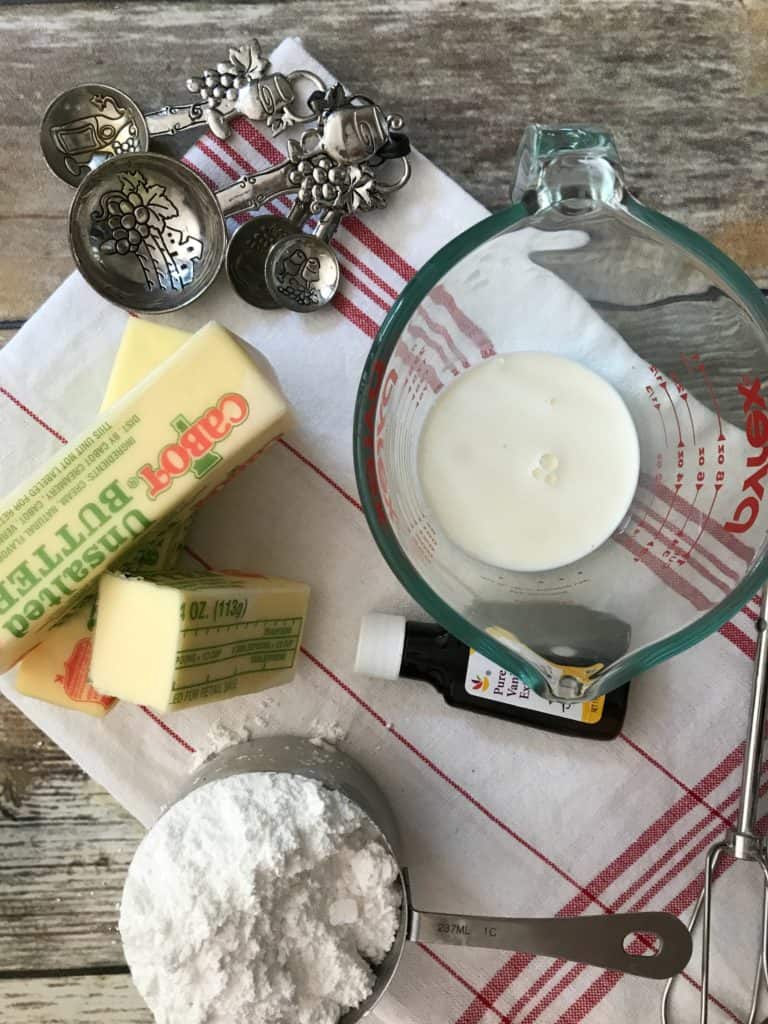 butter, powdered sugar, measuring spoons, vanilla, and heavy cream