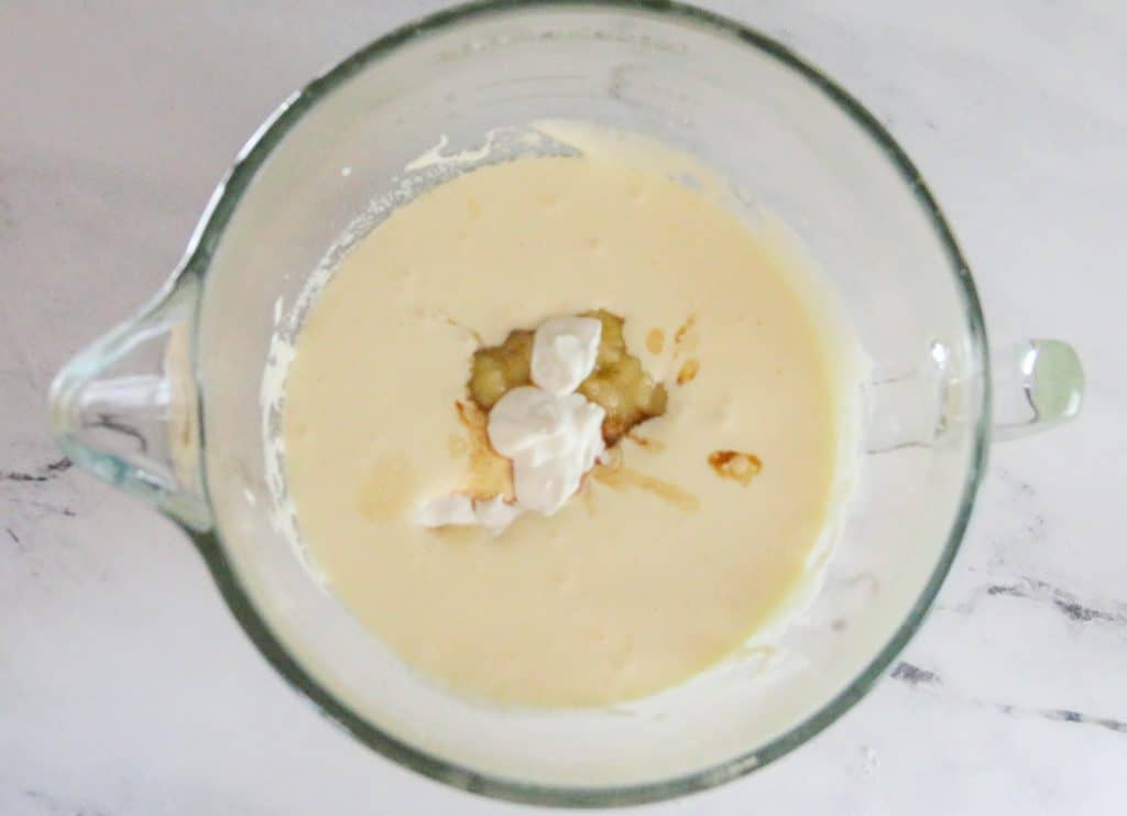 vanilla, bananas, and sour cream added banana bread batter in bowl