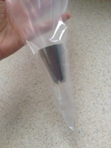 metal piping tip inside a plastic piping bag