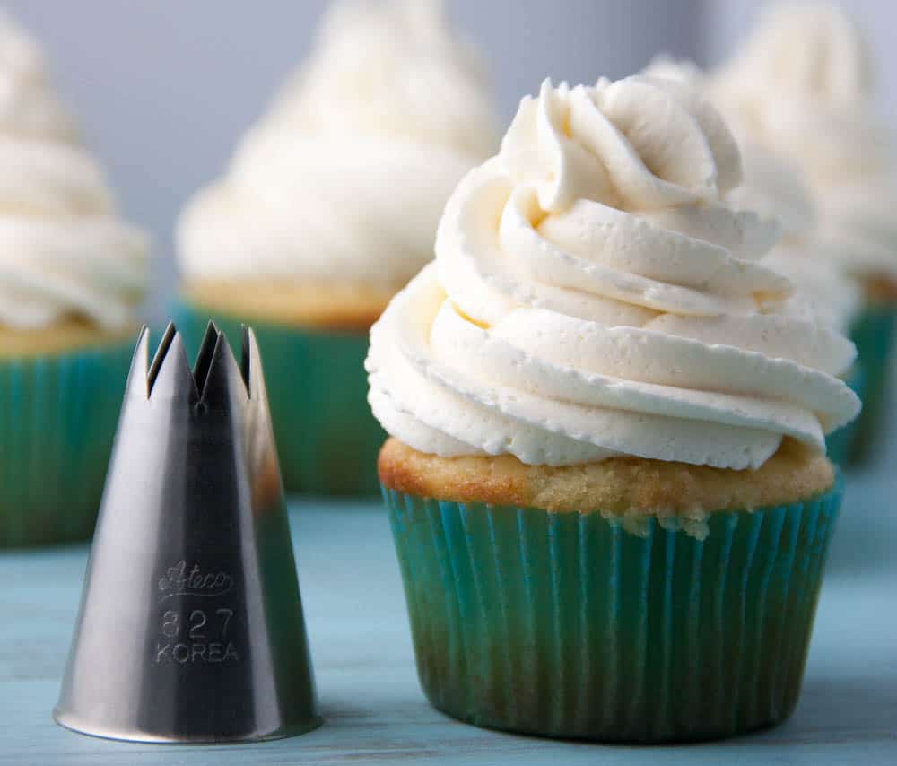 Metal Piping Tip next to a vanilla cupcake in a green cupcake liner
