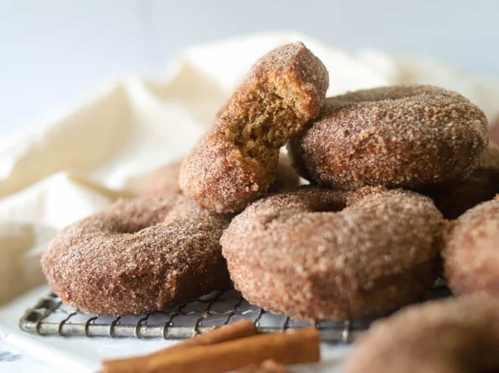 pile of apple cider donuts on a wire rack