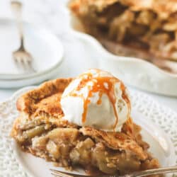 slice of apple pie on a plate topped with icecream and carame
