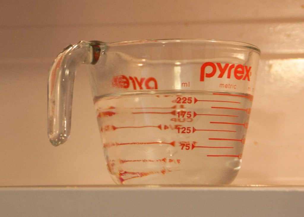 measuring cup full of water in a microwave