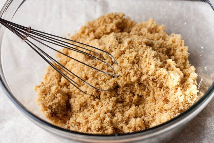 a bowl of brown sugar with a whisk in it