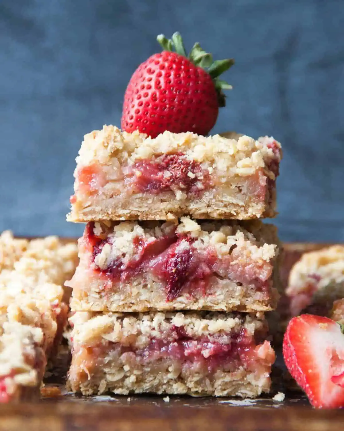 three strawberry rhubarb bars with a strawberry on top