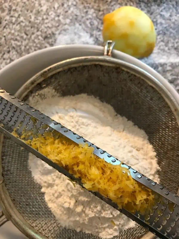 Learn how to make French Madeleines in this step by step baking photo tutorial! Microplane zesting a lemon