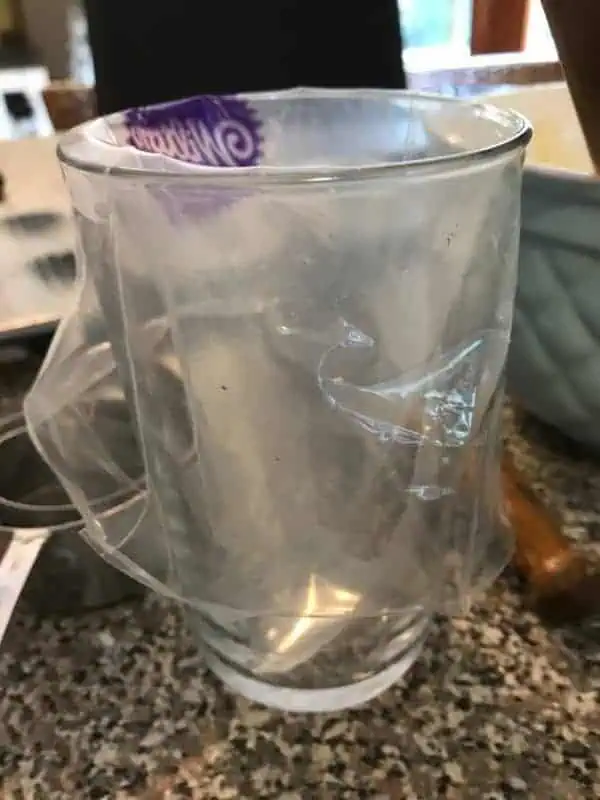 Learn how to make French Madeleines in this step by step baking photo tutorial! tall glass with a piping bag fitted over it