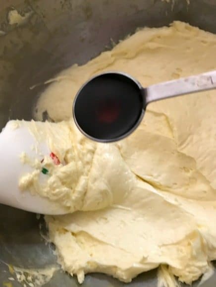 vanilla extract added to bowl of french buttercream