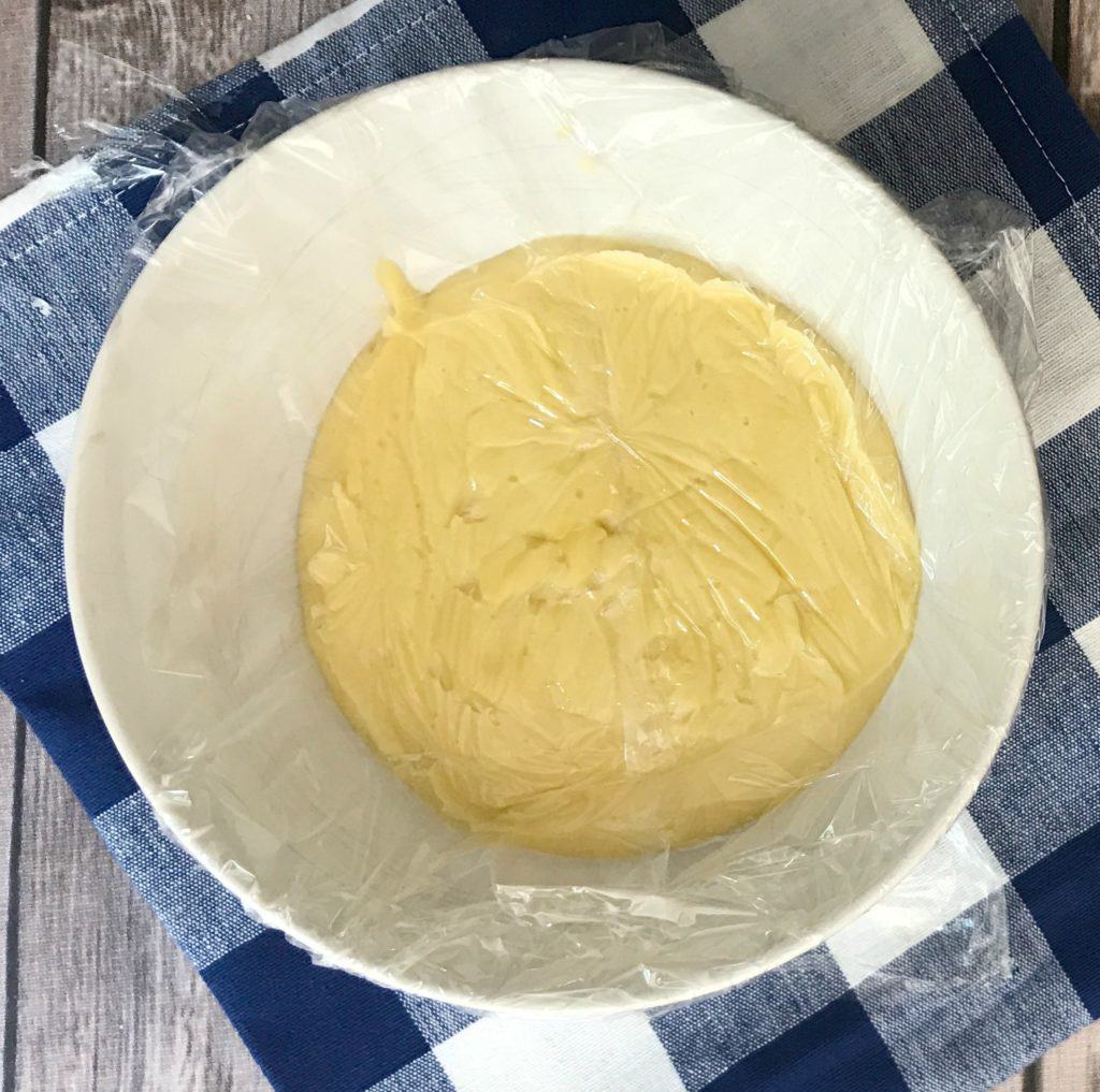 A bowl of custard covered in plastic wrap