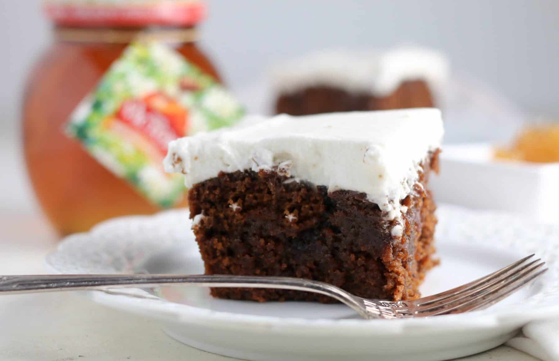 slice of gingerbread poke cake on a plate with a fork