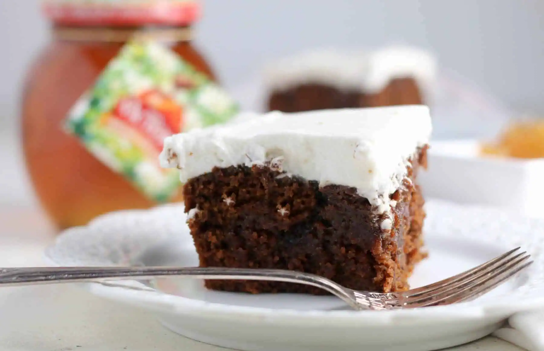 slice of gingerbread poke cake on a plate with a fork