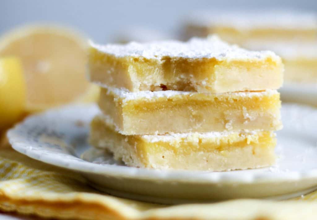 lemon bars stacked on a plate