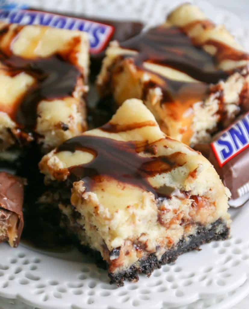 snickers cheesecake bars on a plate