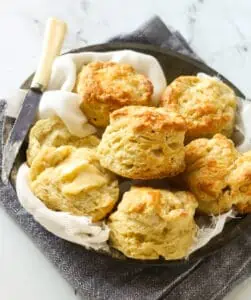 pie plate filled with buttermilk biscuits and a knife on top