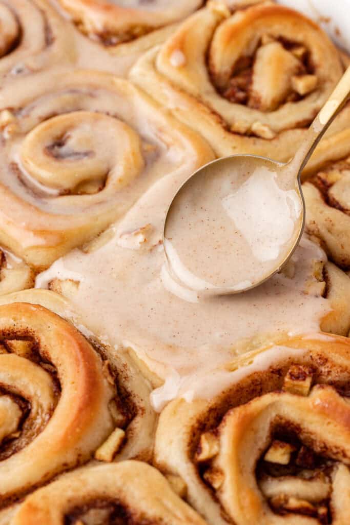 cider glaze spread on top of apple cinnamon yeast rolls
