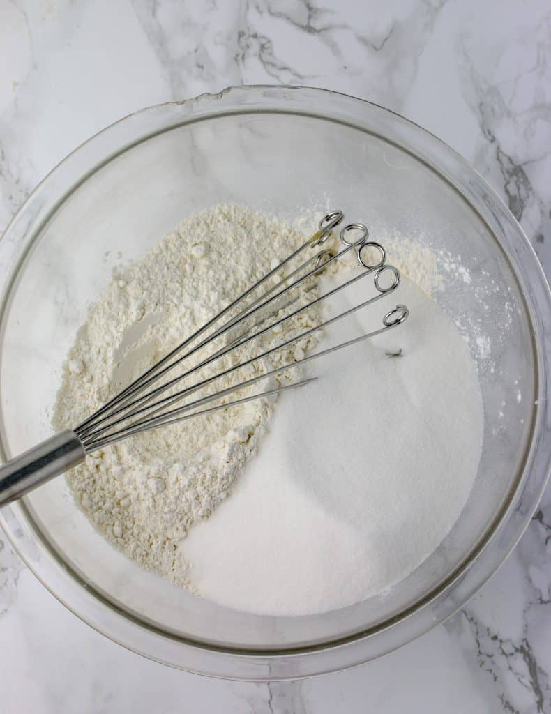 bowl of sugar and flour with a whisk