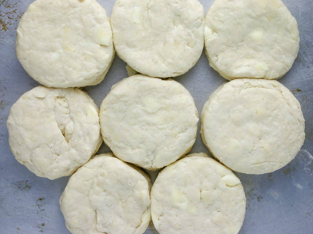 unbaked biscuits close together and touching on a cookie sheet