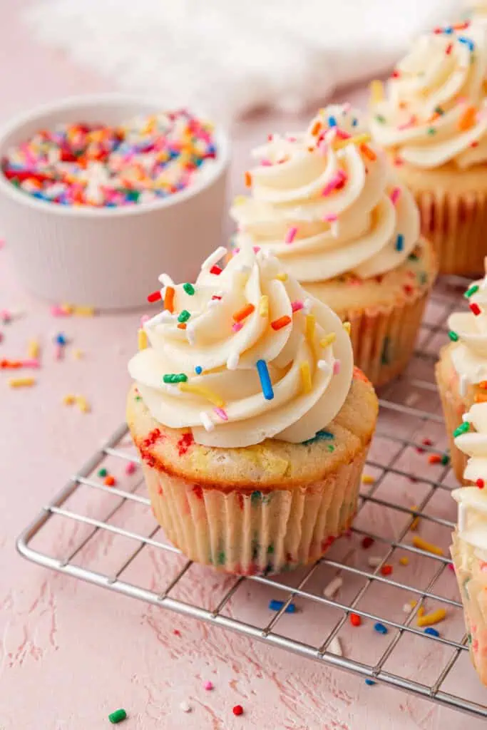 frosted funfetti cupcakes on a wire rack