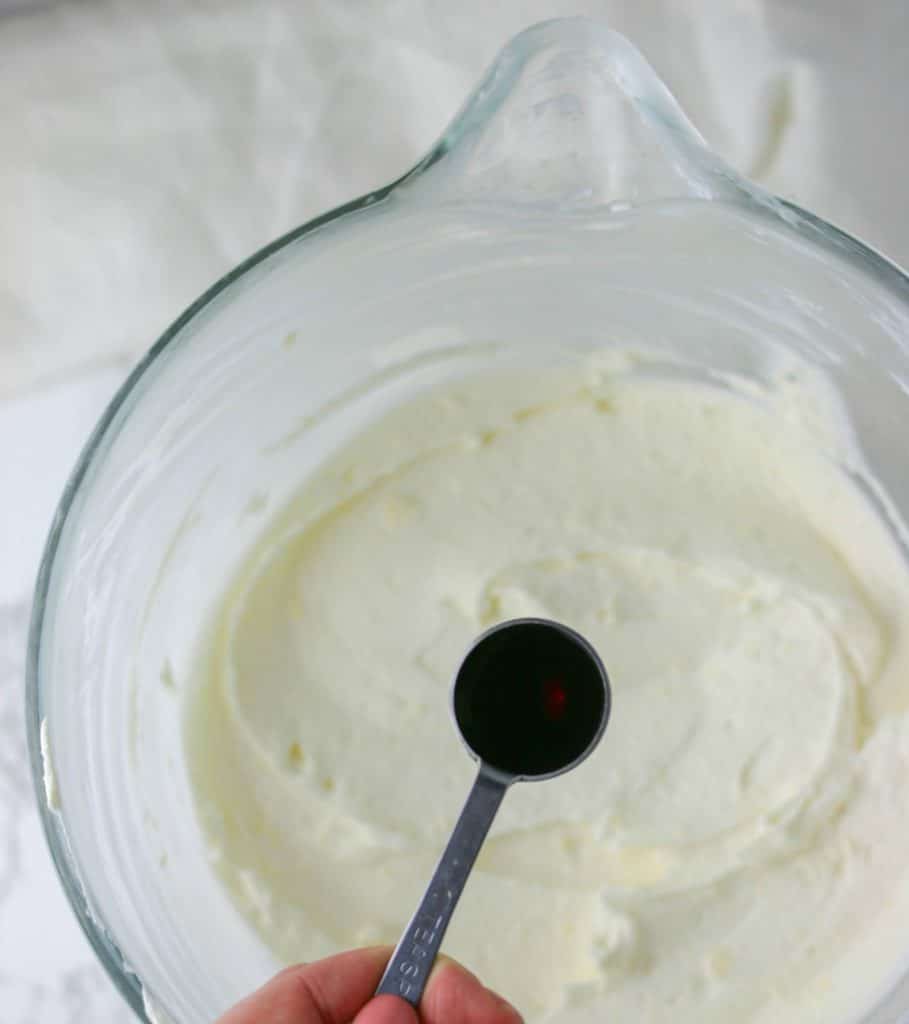 vanilla extract added to cream cheese frosting bowl 