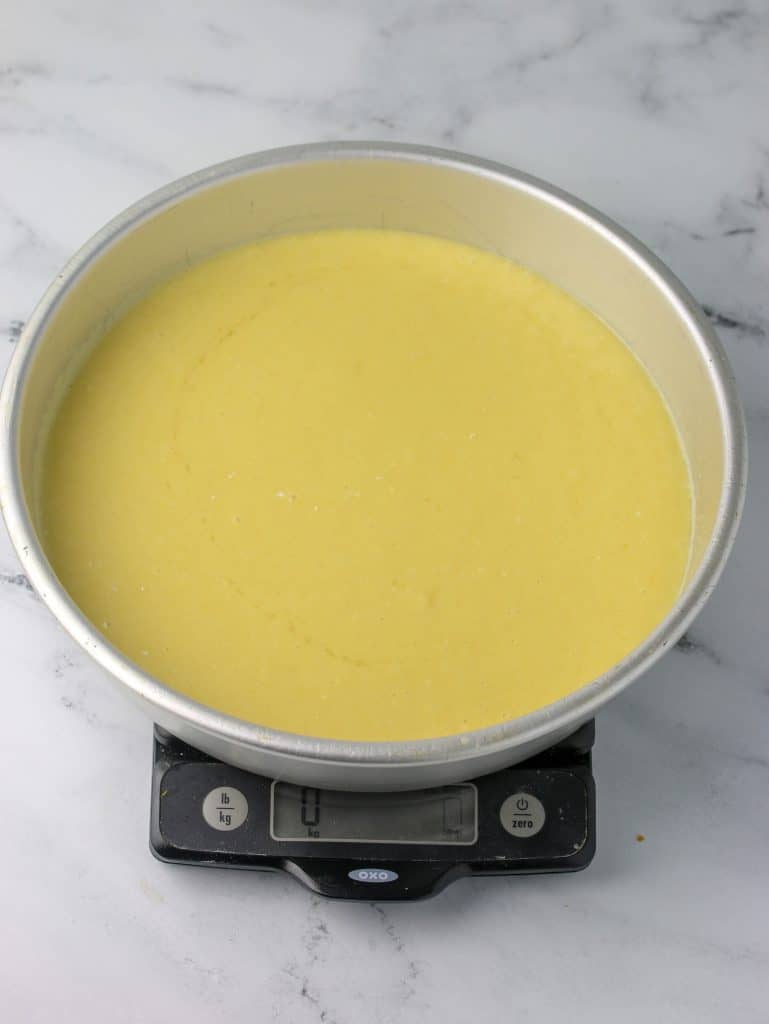 cake pan with batter in it on a kitchen scale