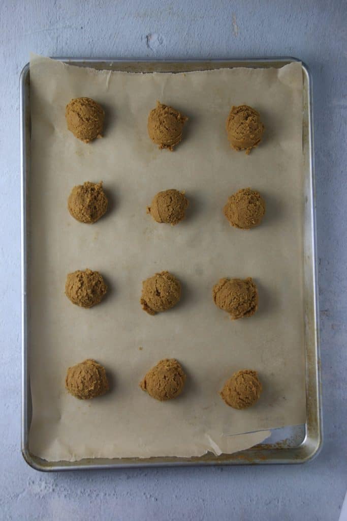 ginger cookie dough scooped into balls on a cookie sheet