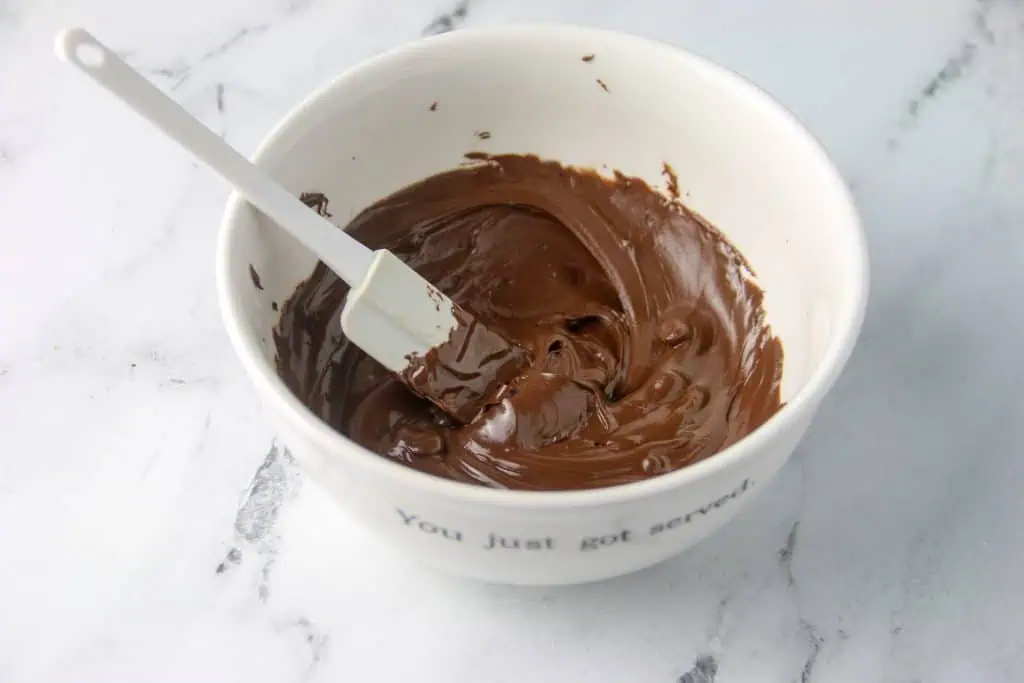 a bowl of melted chocolate with a mini spatula