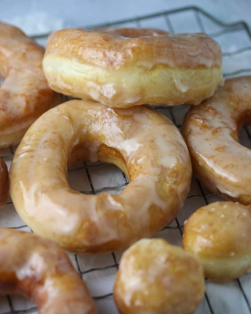 glazed yeast donuts on a cooling rack