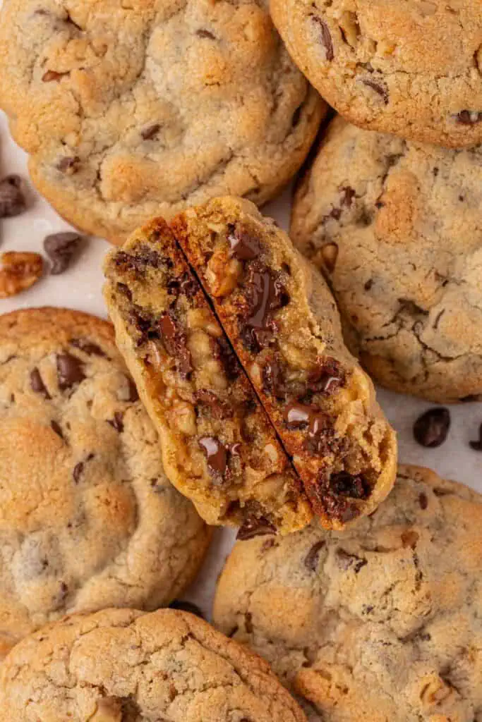 a bunch of cookies placed close together with the middle cookie broke in half