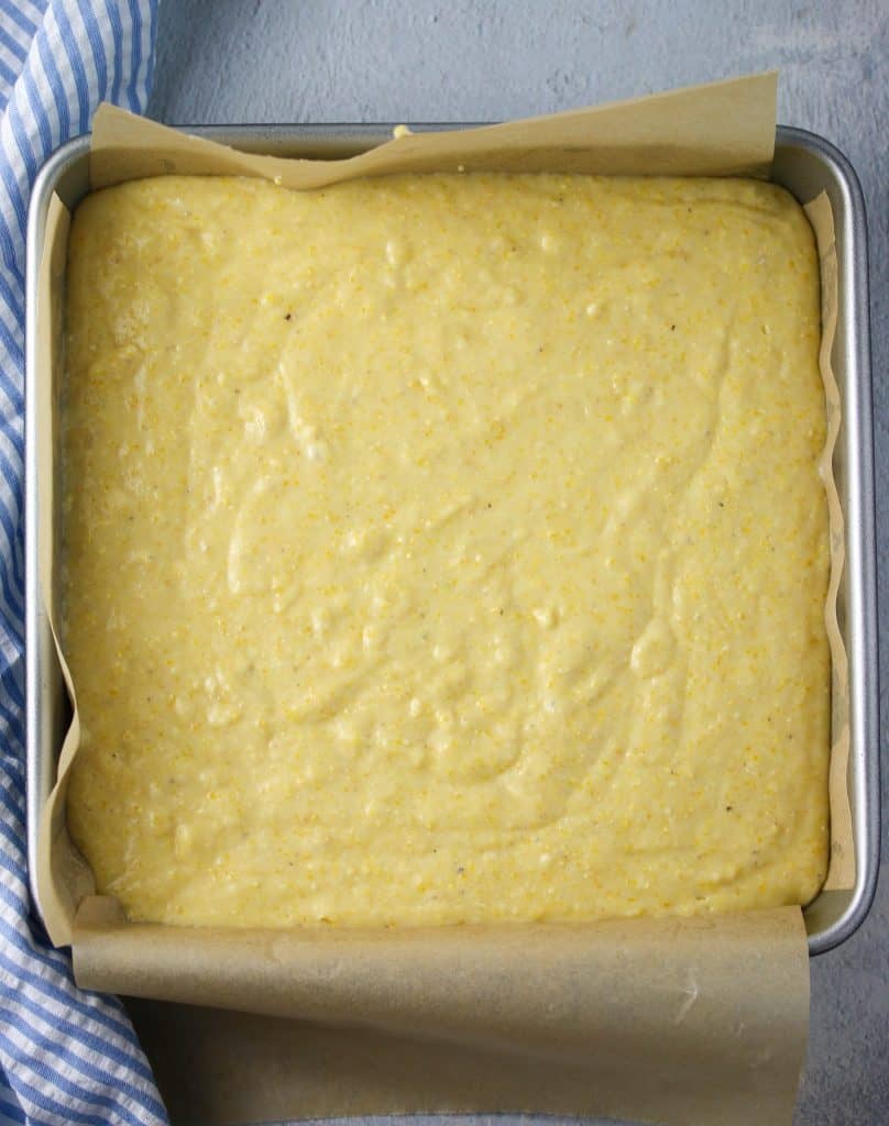 cornbread batter uncooked in a square pan