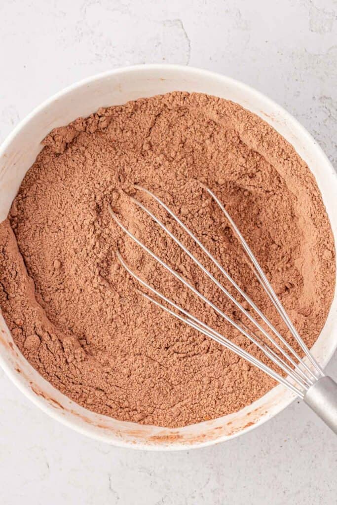 chocolate cake dry ingredients in a bowl with a whisk