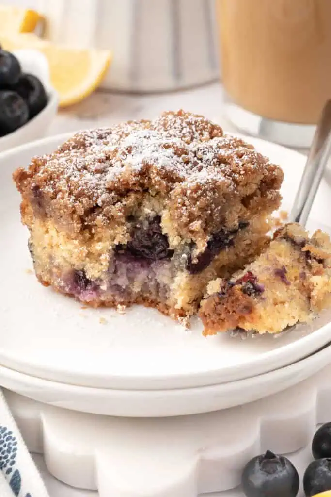 slice of blueberry crumb cake on a plate with a fork