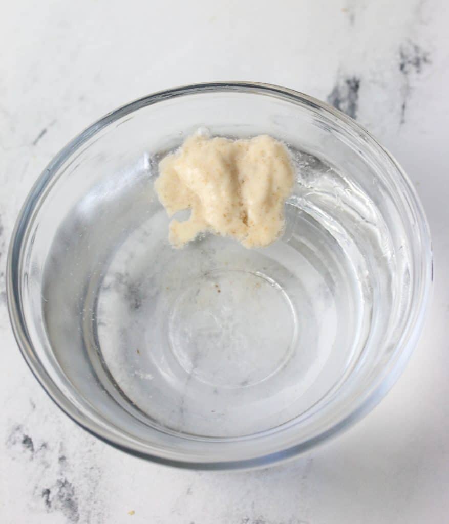 sourdough starter floating in a bowl of water