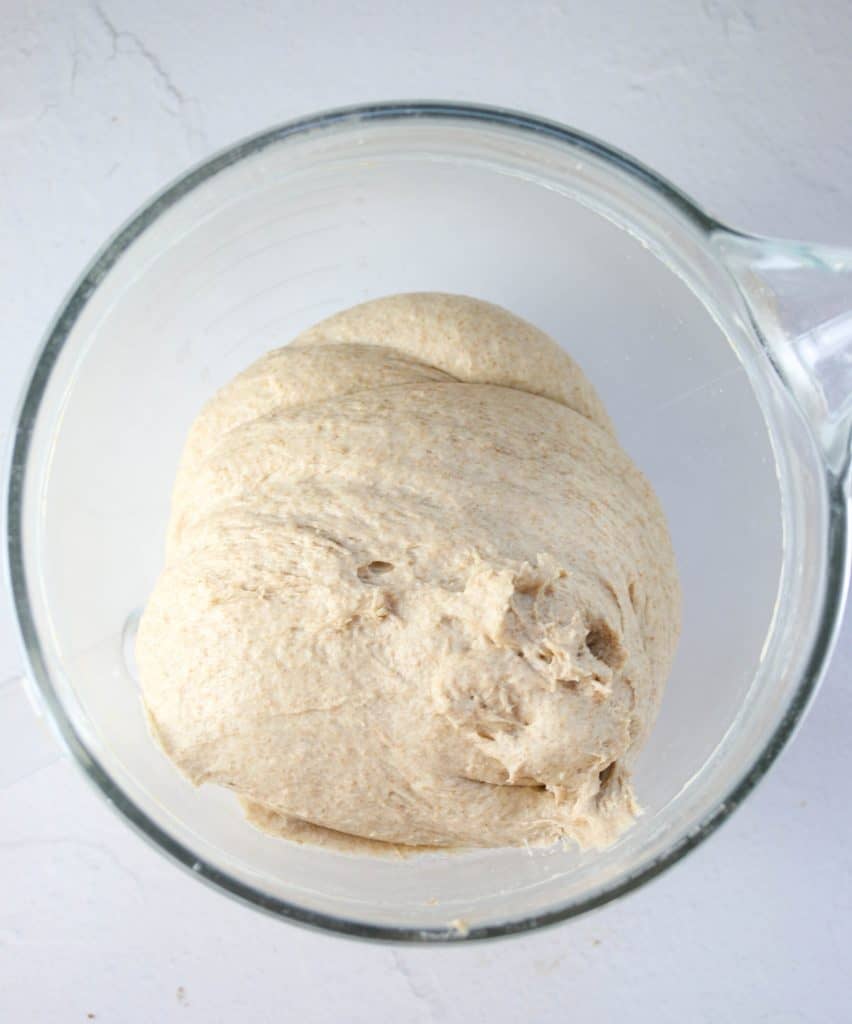 whole wheat sandwich bread dough that's been kneaded in a mixing bowl