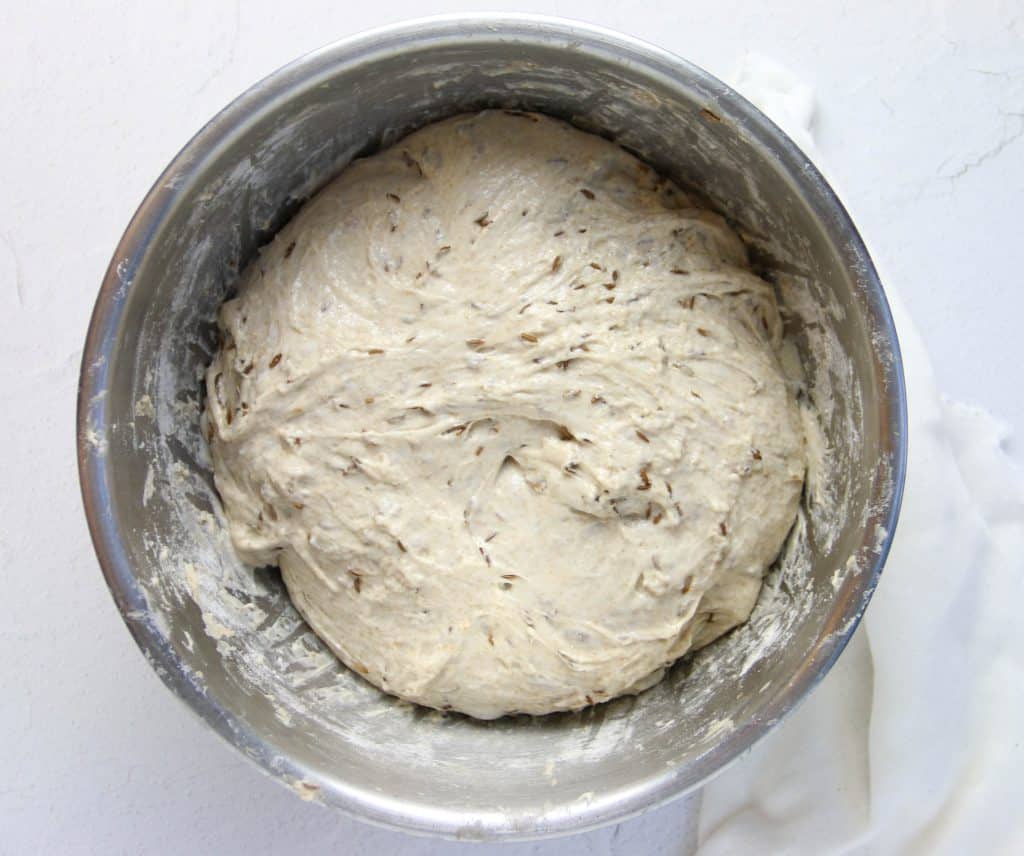 sourdough rye bread dough in a bowl that's risen and puffy