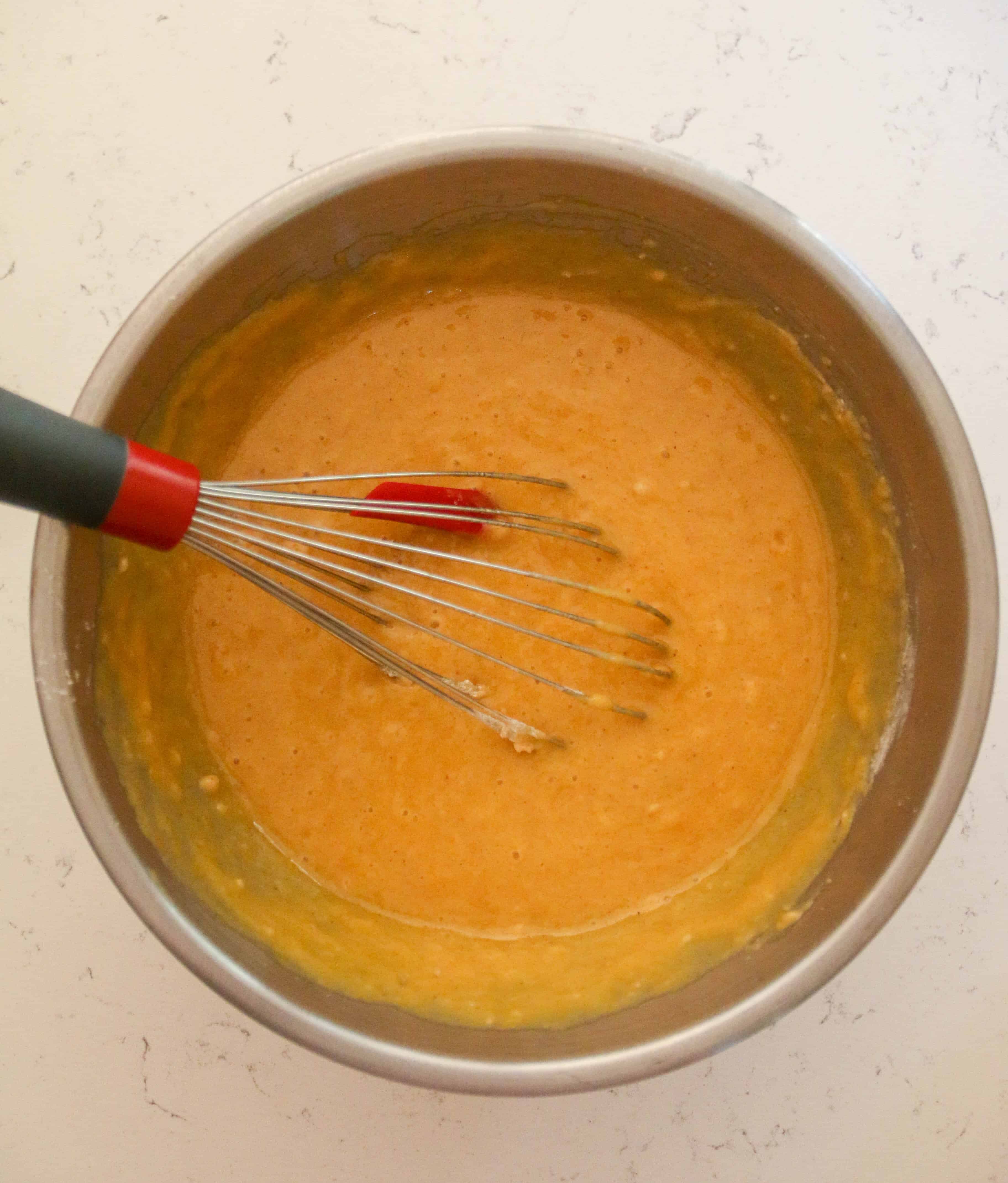 bowl of squash bread batter in a bowl with a whisk