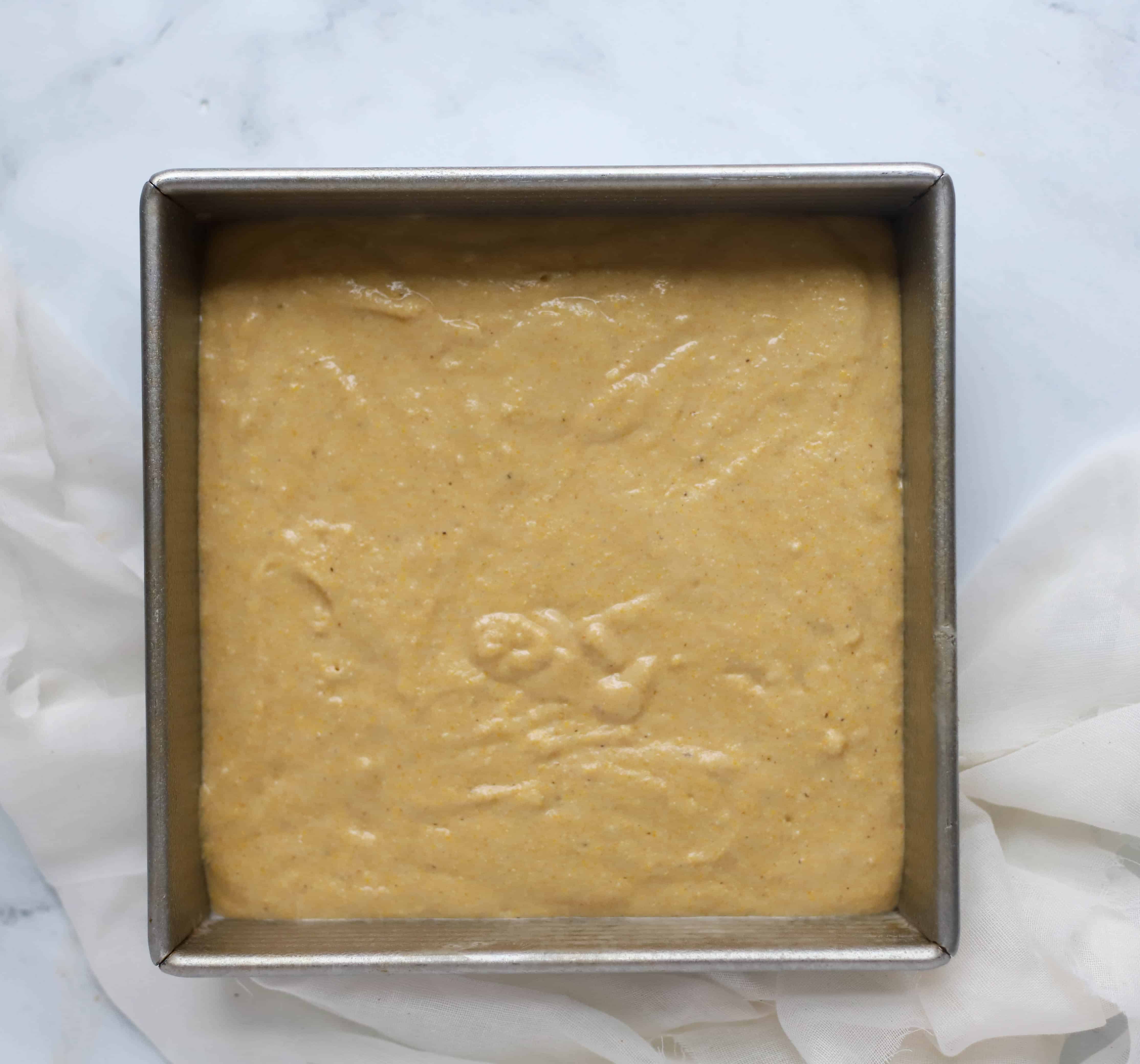 healthy cornbread batter in a square pan