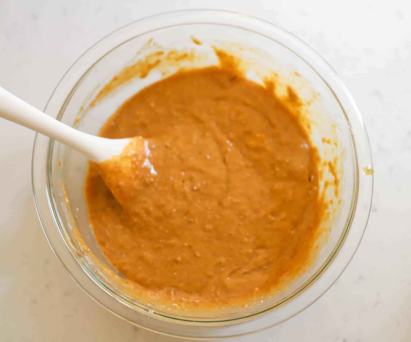 sweet potato muffin batter in a bowl with a spatula