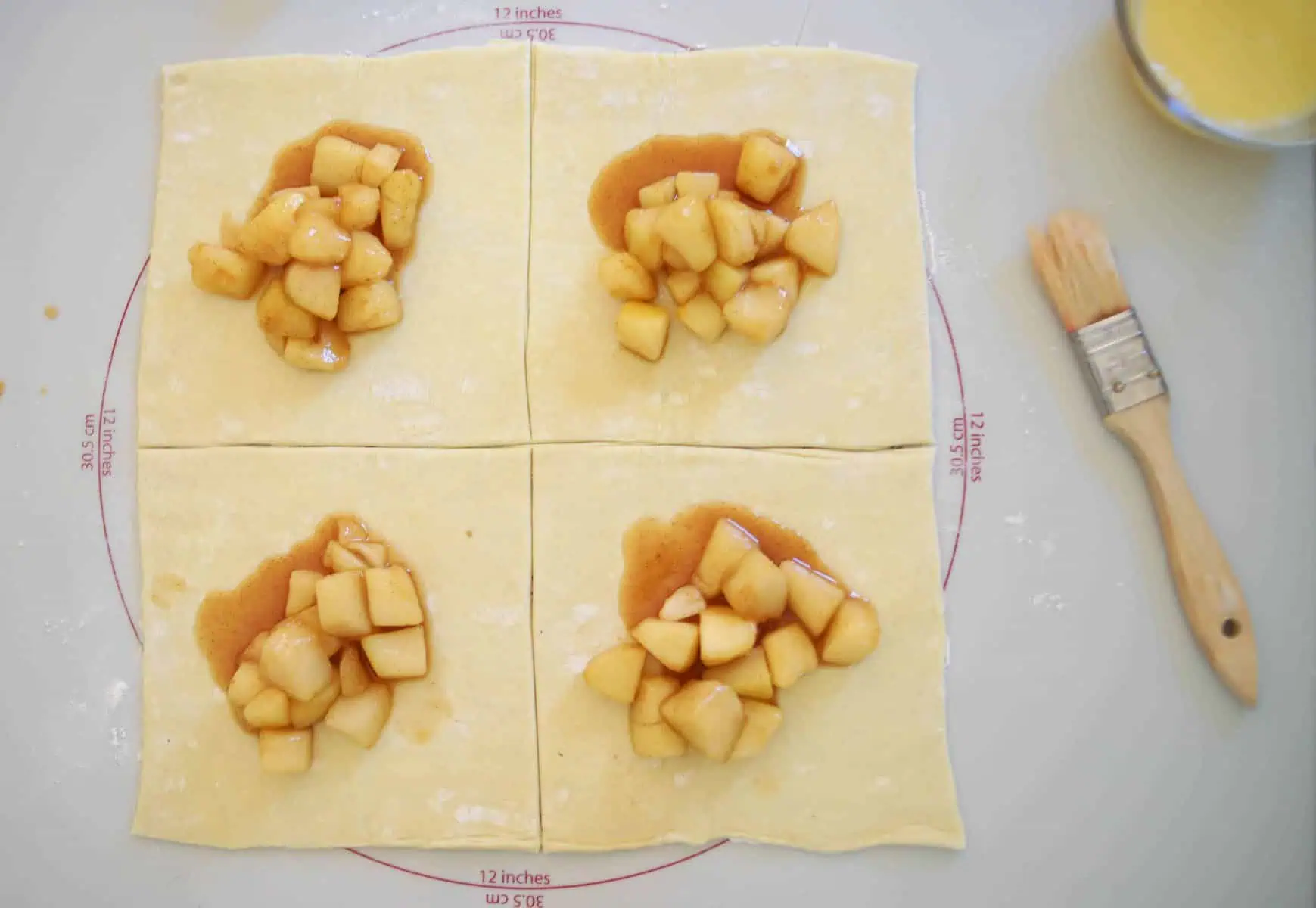 four squares of puff pastry with pear filling in the center