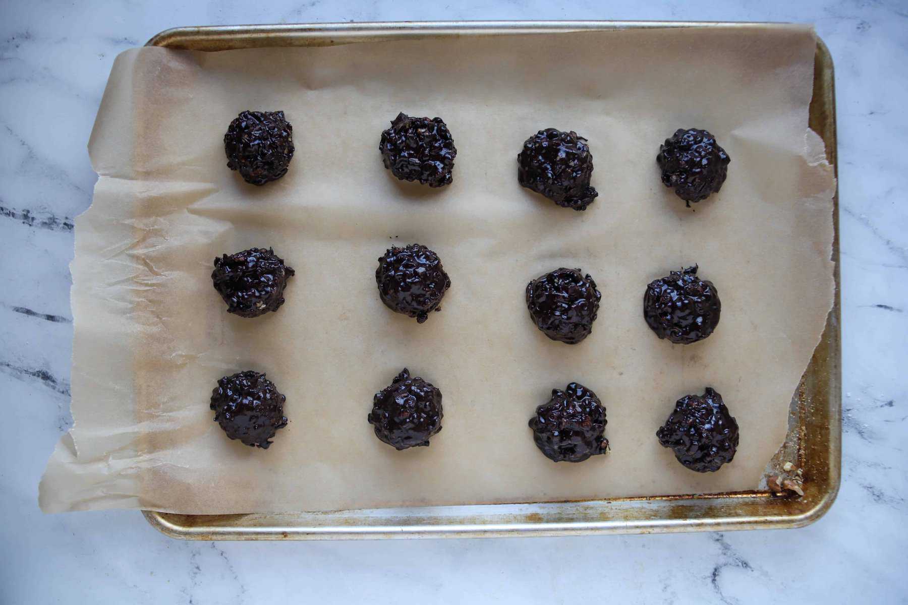 twelve cookies scooped onto a baking sheet