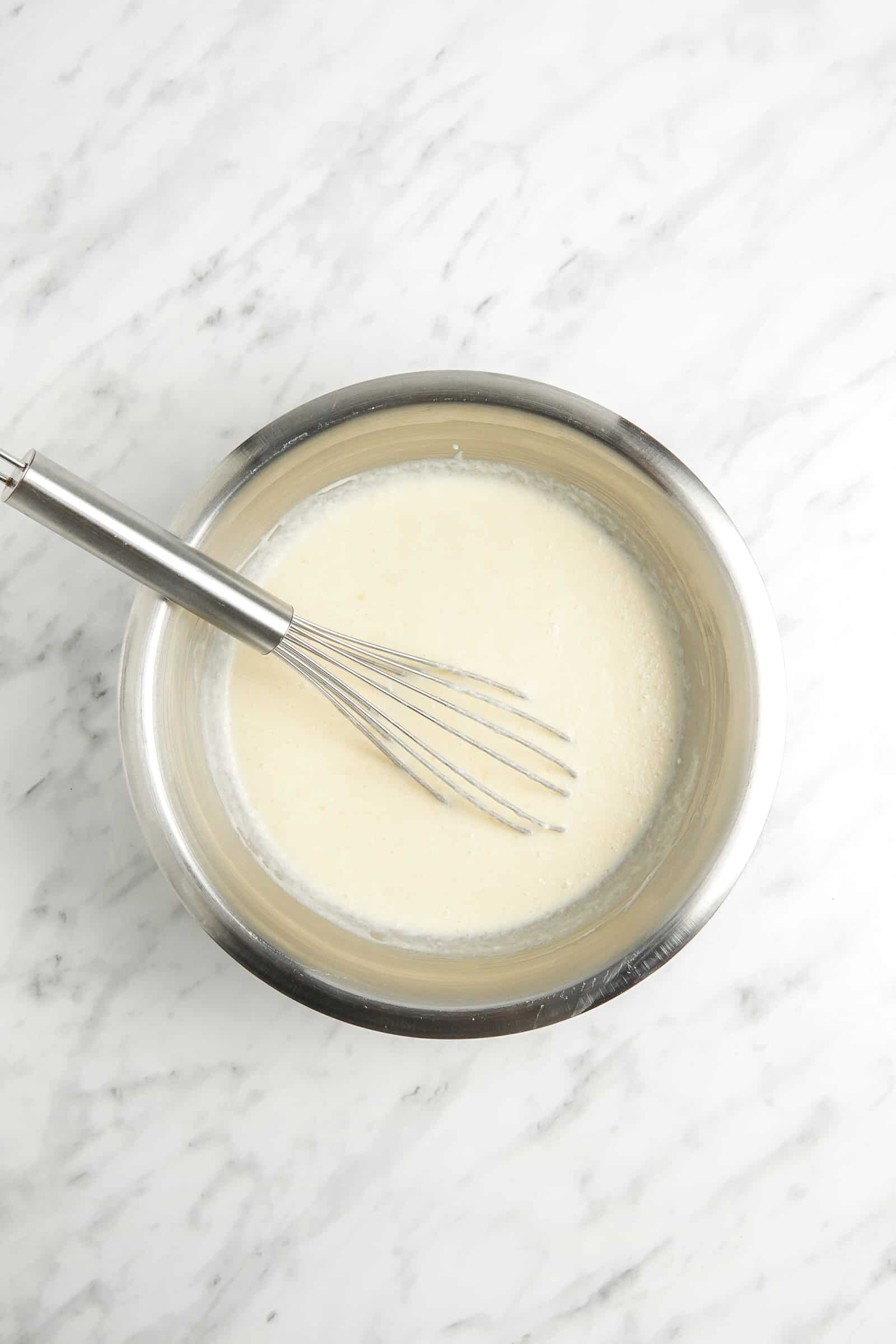 smooth crepe batter in a bowl with a whisk