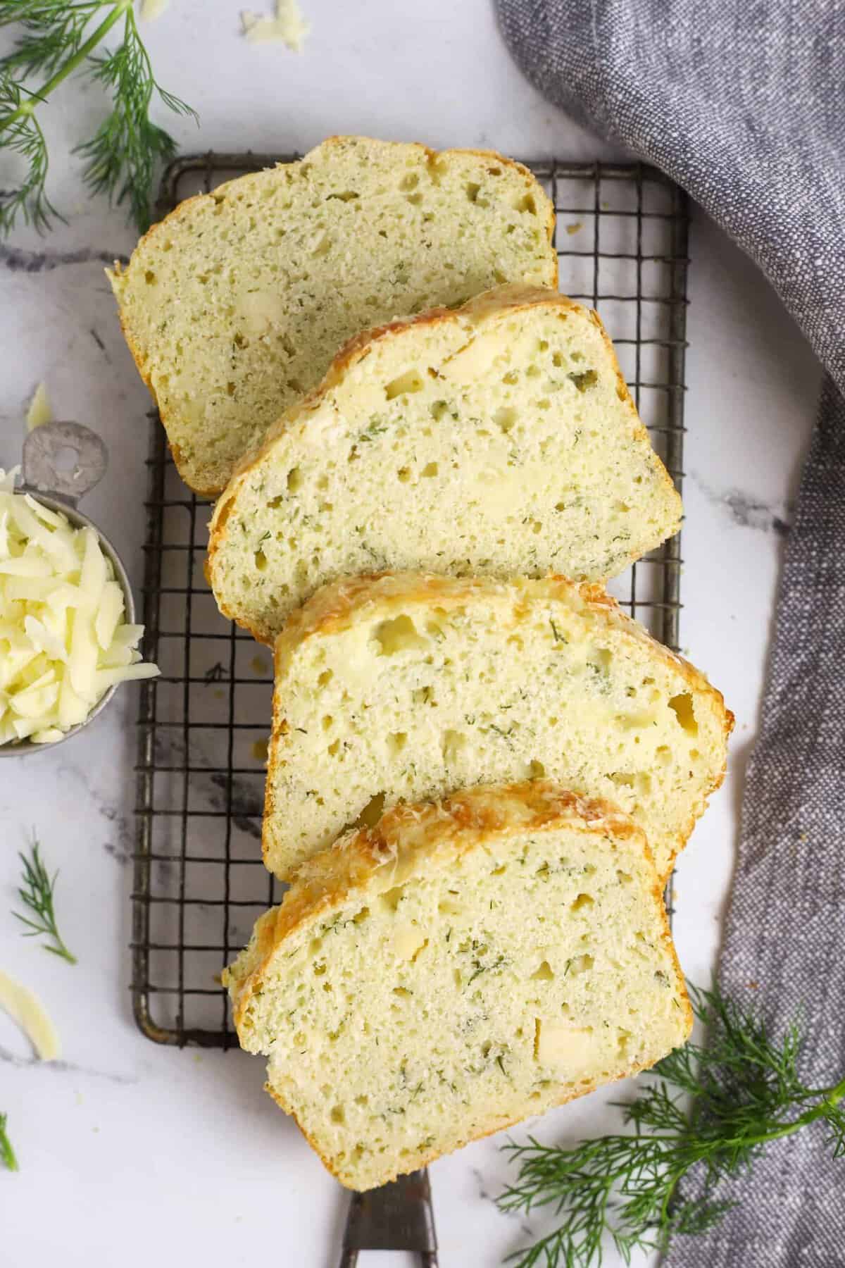 four slices of dill bread on a cooling rack